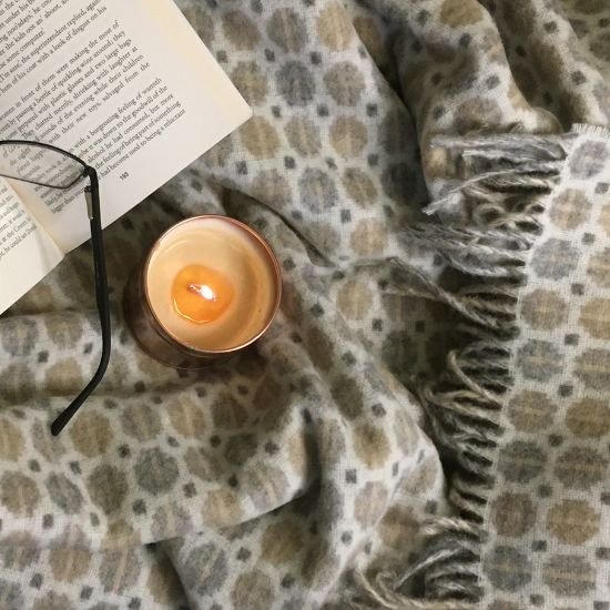 Milan Natural Merino Throw styled with candle book and glasses