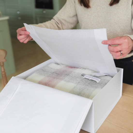 Unboxing a beautifully wrapped Solway Blankets gift – a British-made wool throw presented in tissue-lined luxury packaging, perfect for birthdays, weddings and thoughtful occasions.