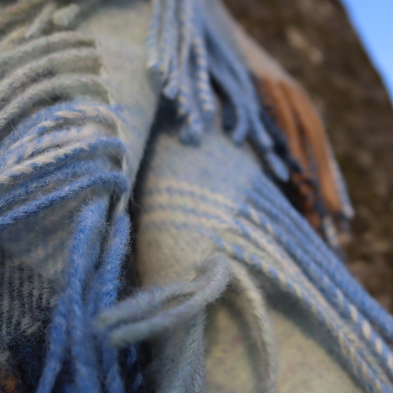Close-up of soft woven blanket fringe in natural blue and beige tones, highlighting texture and weave – featured in the By Material Blanket Collection.