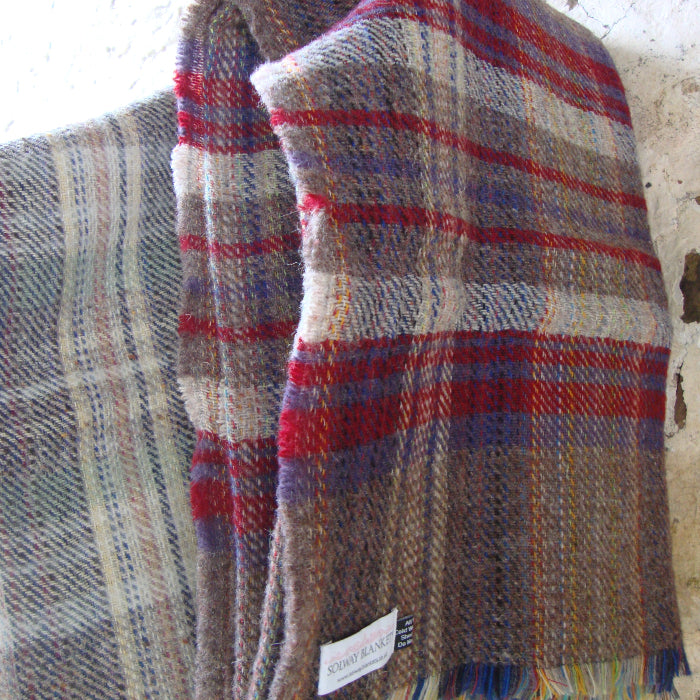 Recycled plaid fabric rug with red, blue, and brown colors on a textured background
