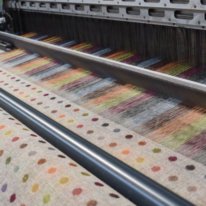 Textile manufacturing process with colourful yarns on a loom. Creating a spot design in blanket cloth for Solway Blankets