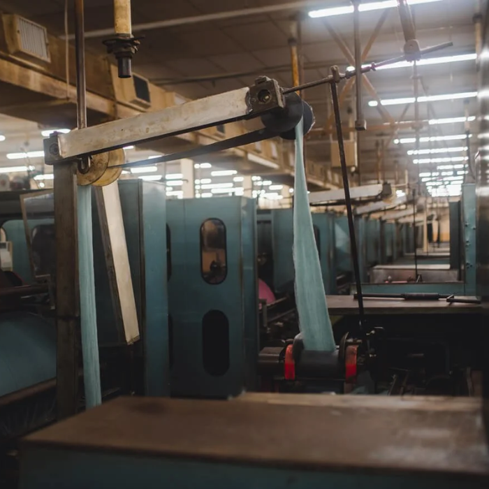 Wool being processed through the carding machine in a traditional British weaving mill before going onto spinning