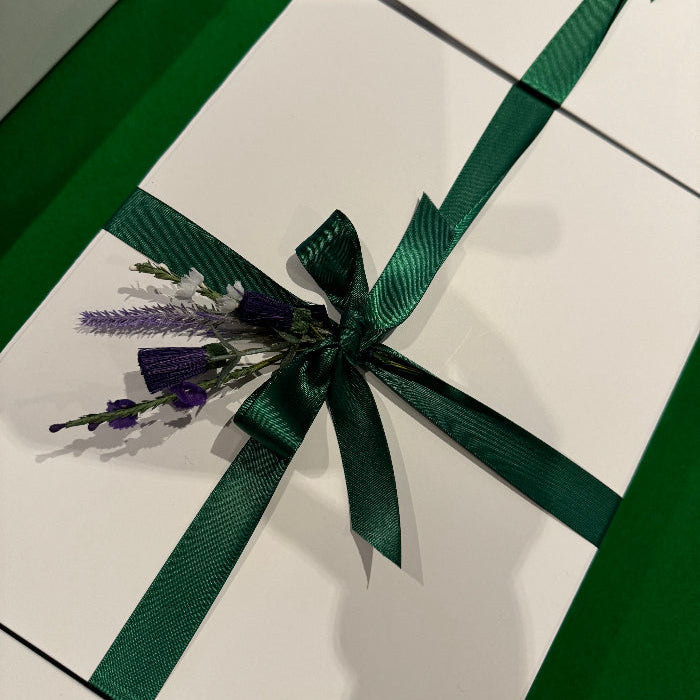 Corporate Tailored white gift box with green brand coloured ribbon and floral decoration.