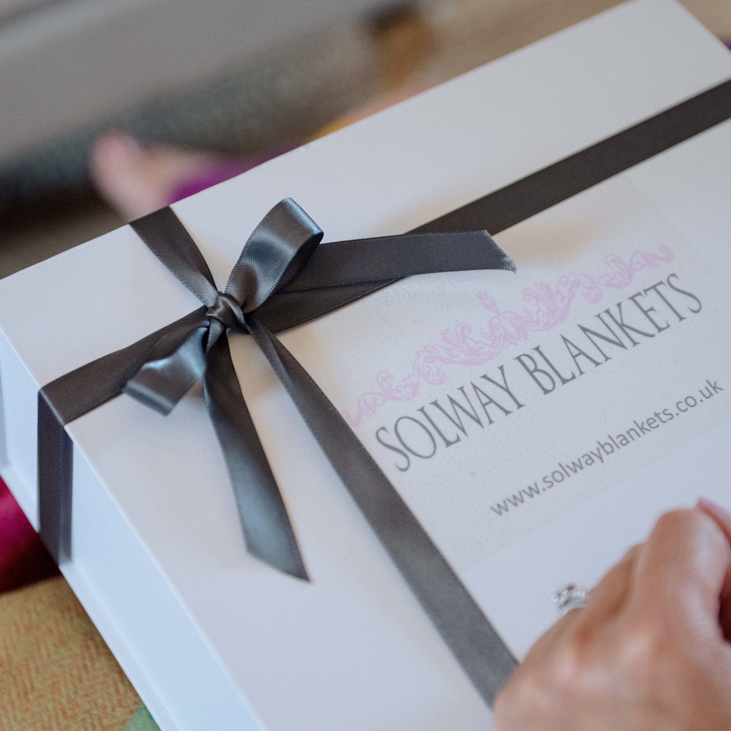 White gift box with a black ribbon and 'SOLWAY BLANKETS' branding.