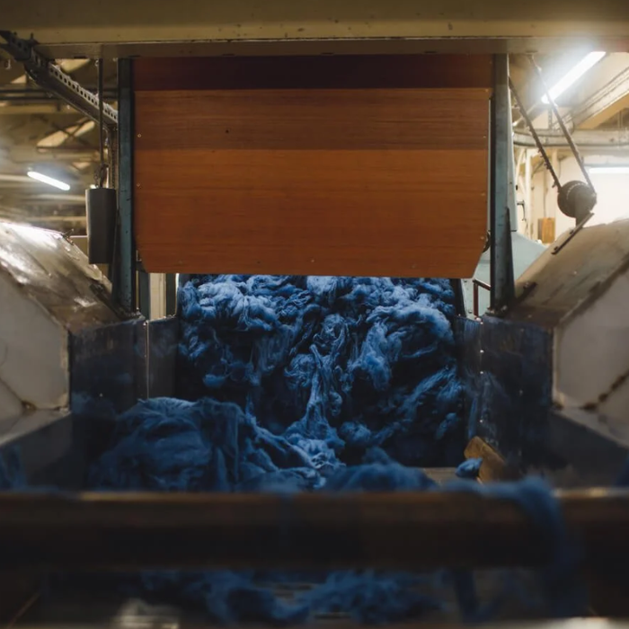 Dyed blue wool being blended in a traditional weaving mill factory setting