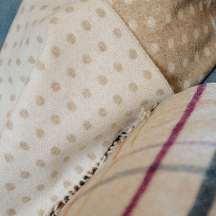 Close up of beige and cream spot reversible blanket
