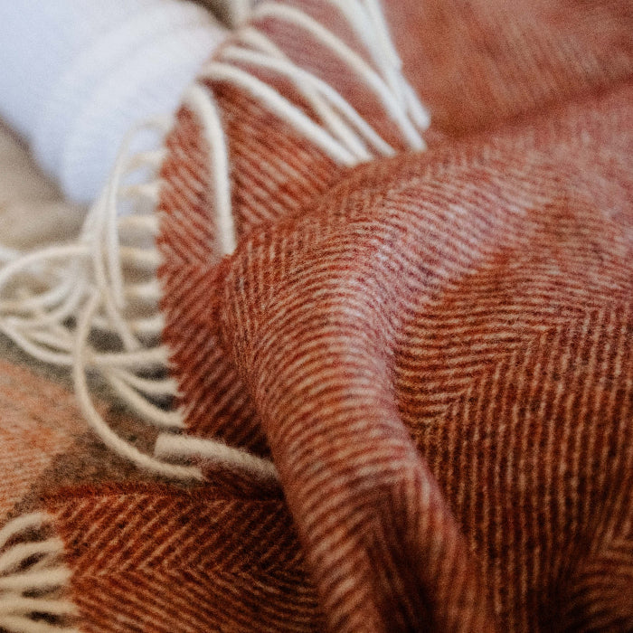 Close-up of a Brick, Terracotta Herringbone Shetland Wool Blanket Throw with white twisted fringes