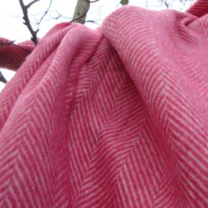 Close up of pink herringbone style fabric throw draped over a tree