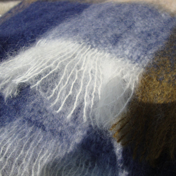 Close-up of a blue and brown plaid the Denim & Stone Mohair Throw showing the lustre and delicate fringe edge
