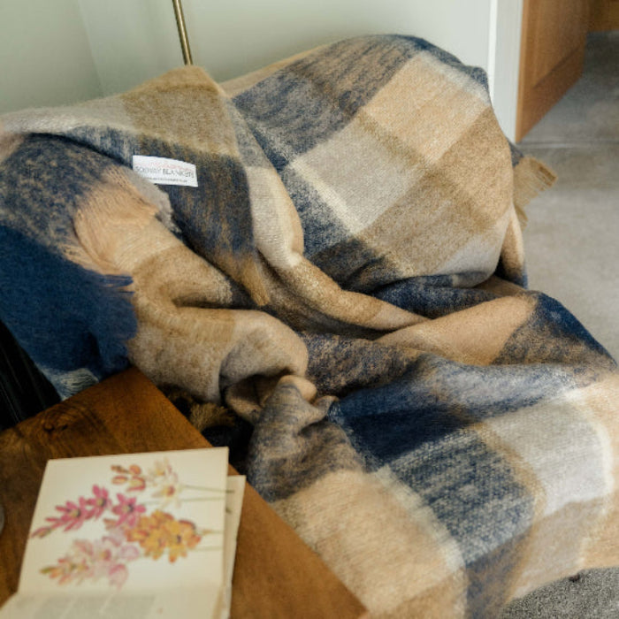 Denim & Stone Mohair Throw, blue, navy and tan coloured plaid blanket draped over a chair with an open book