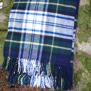 Dress Gordon Tartan Plaid Rug blanket with dark blue, dark green and white colours draped over a tree branch.