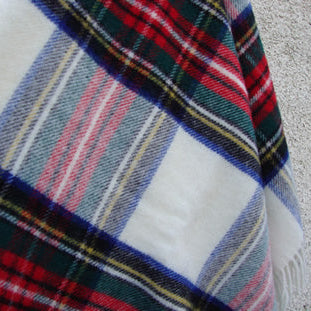 Dress Royal Stewart Tartan Plaid natural wool blanket with red, blue and white colours on a textured surface