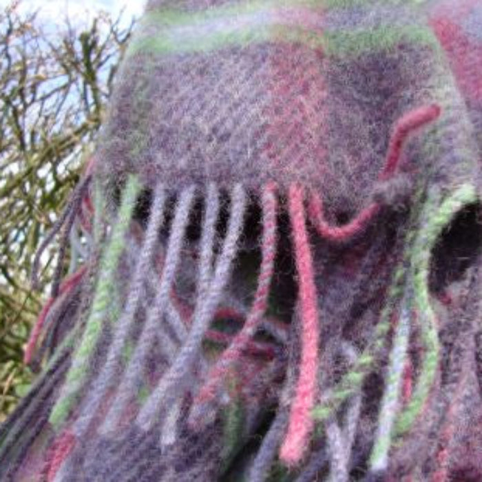 Textured wool blanket with fringes in a natural outdoor setting