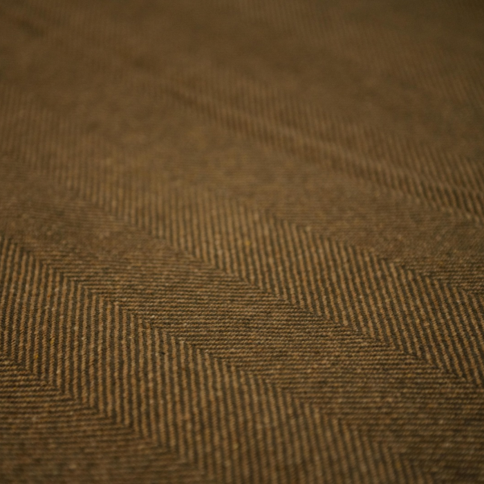 Close-up of the substantial two-tone herringbone weave in a Scottish lambswool blanket in olive-grey and ochre.