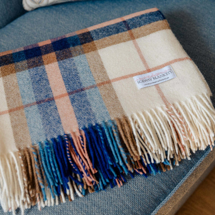 Falmouth Blue & Ivory Check Shetland Wool Blanket with fringes on a grey/blue couch