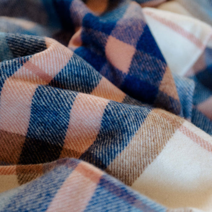 Close-up of Falmouth Blue & Ivory Check Shetland Wool Blanket a plaid with blue, pink and white colours.