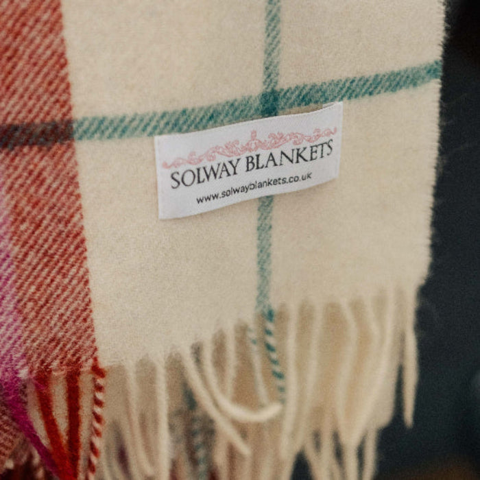 Falmouth Red & Ivory Check Shetland Wool Blanket with fringes and Solway Blankets label on a dark background