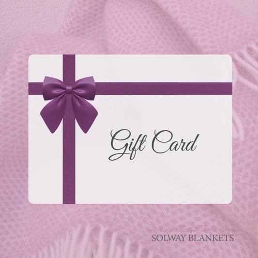 Gift card with purple ribbon and bow on a pink blanket, branded 'Solway Blankets'.