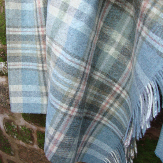 Blue Glen Coe Shetland Pure New Wool plaid blanket with fringes on a natural background