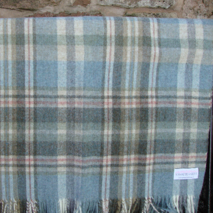 Glen Coe Shetland Pure New Wool Blanket with blue and grey colours on a stone surface