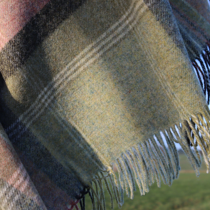 Green Kintyre Check Shetland Wool Throw Blanket with fringes in a natural outdoor setting