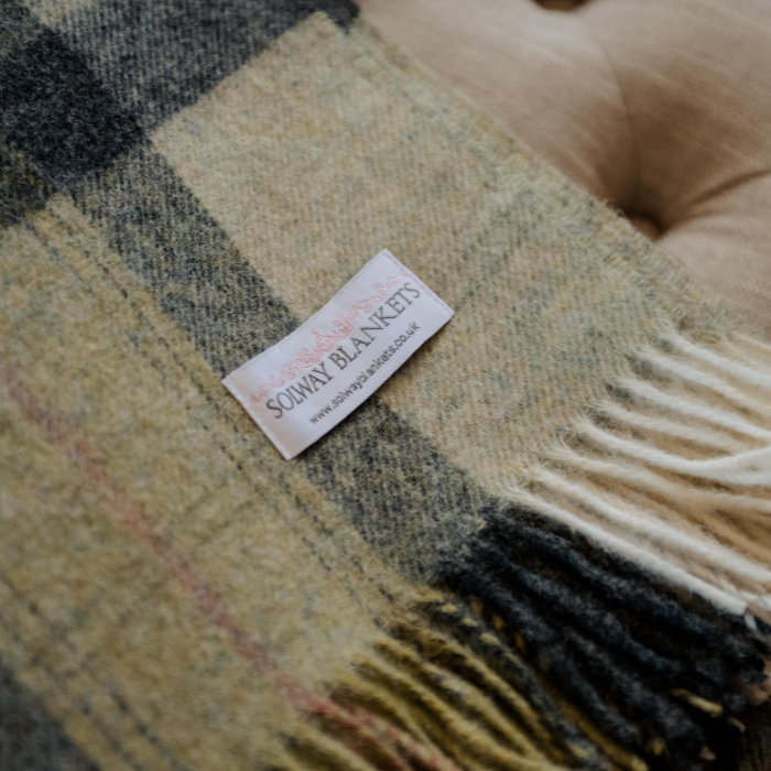 Green Skye Check Shetland Wool Throw with a visible Solway Blankets brand label on a textured surface