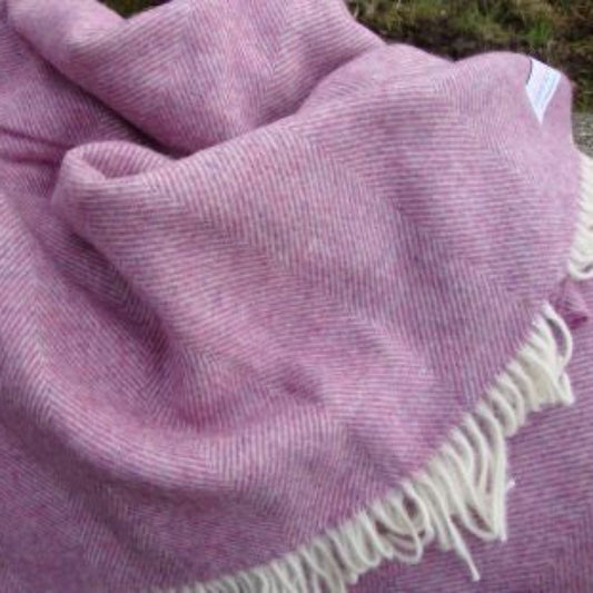 Heather Herringbone Shetland Wool Blanket with white fringe on a grassy background