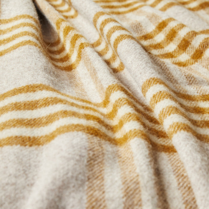 Close up of a mustard and oatmeal checked wool blanket