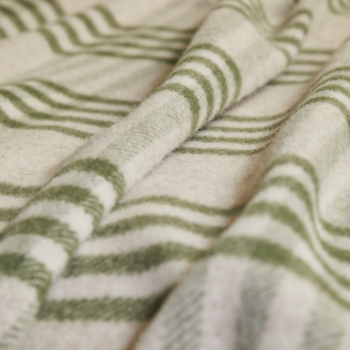 Close up of an olive green and beige checked wool blanket 