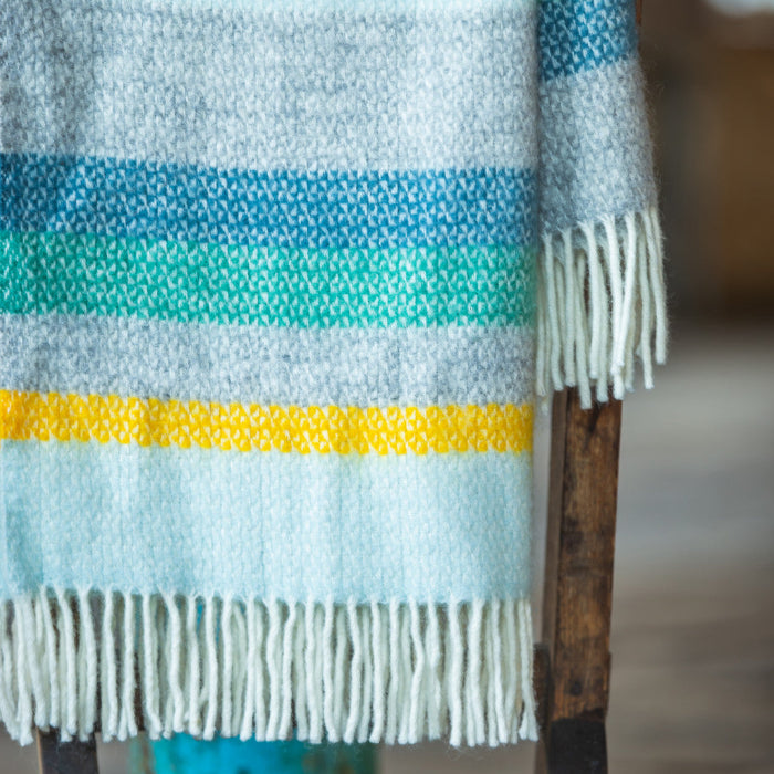 Colourful striped wool blanket with fringes in an industrial setting