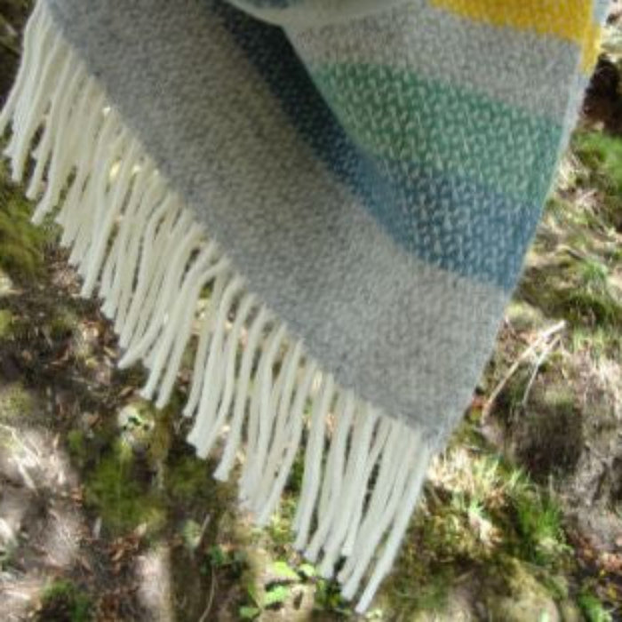 Textured wool blanket with fringes on a natural background