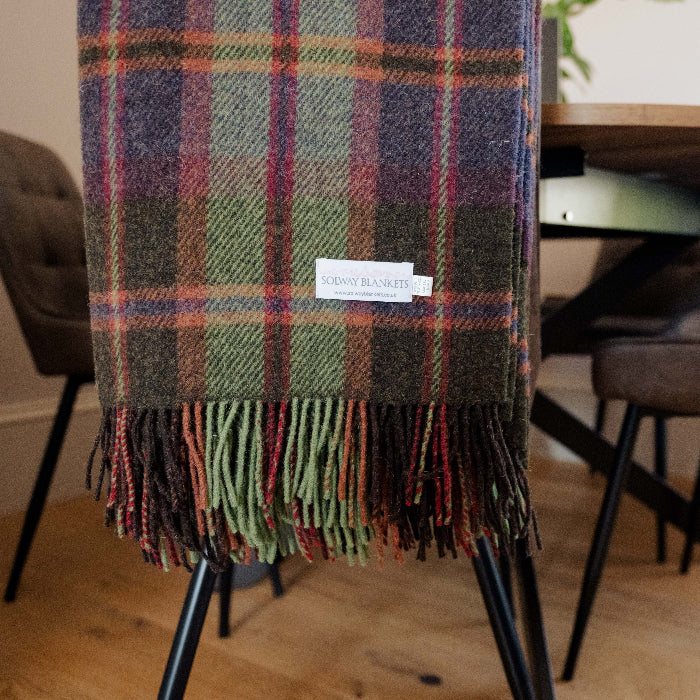 Plaid woolen blanket displaying a Solway Blankets label draped over dining chair 
