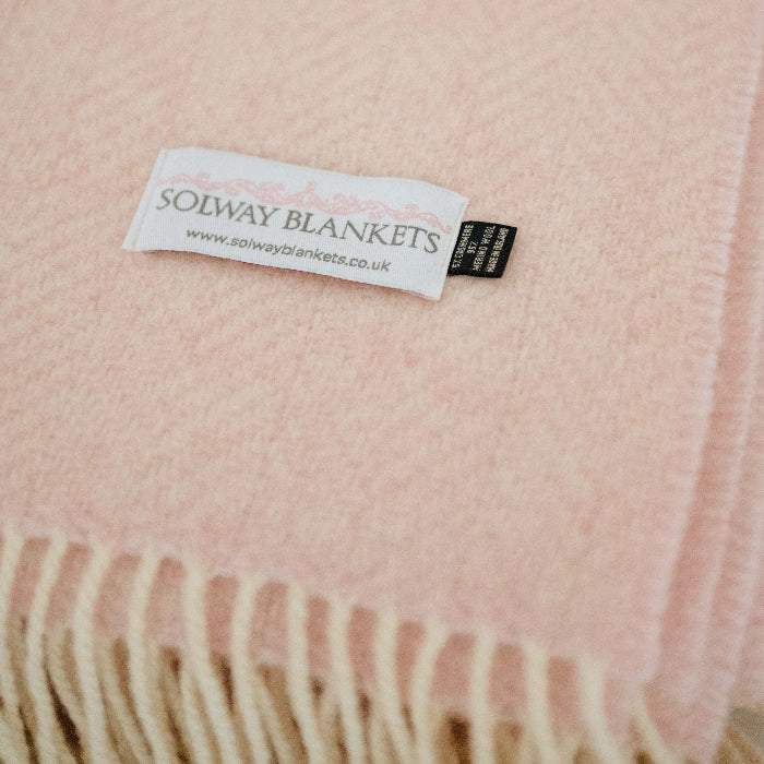 Close-up of a pink cashmere throw with a Solway Blankets label.