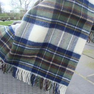 Muted Blue Stewart Tartan Plaid pure wool blanket with fringes on a chair outdoors
