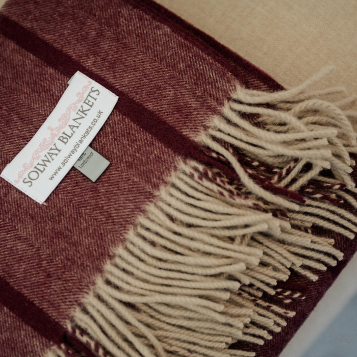 Close-up of fine herringbone weave and damson and ivory windowpane check on plum cashmere