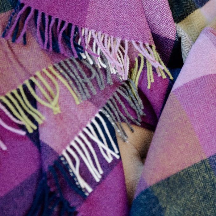 Close up of a colorful plaid fabric throw with a checkered pattern
