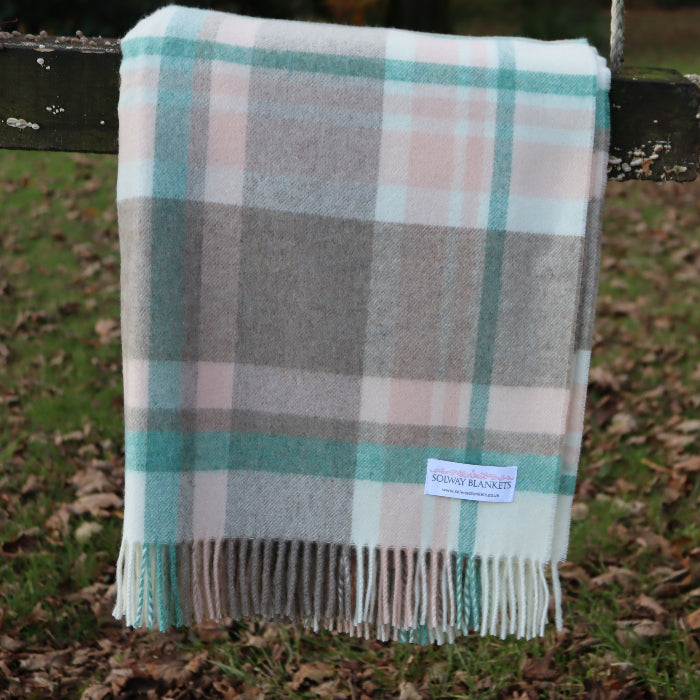 Plaid blanket with a visible Solway Blankets label on a wooden swing outdoors.