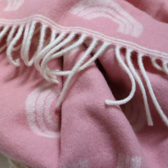 Close-up of a Rainbow Pink Merino Wool Baby Blanket with white fringe 