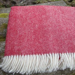 Red Herringbone Shetland Wool Blanket Throw with fringes on a stone surface