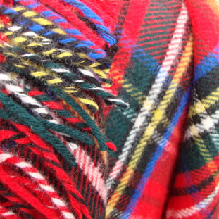 Close-up of colourful Royal Stewart Tartan Rug Blanket with red, blue, yellow, and green patterns.