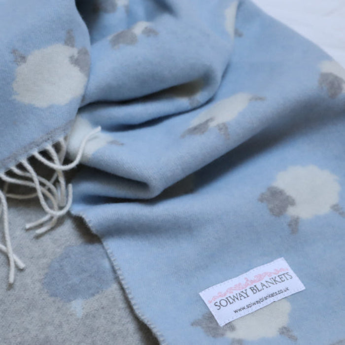 Sheep Blue Merino Wool Baby Blanket with cute sheep pattern and Solway Blankets brand label on a white background