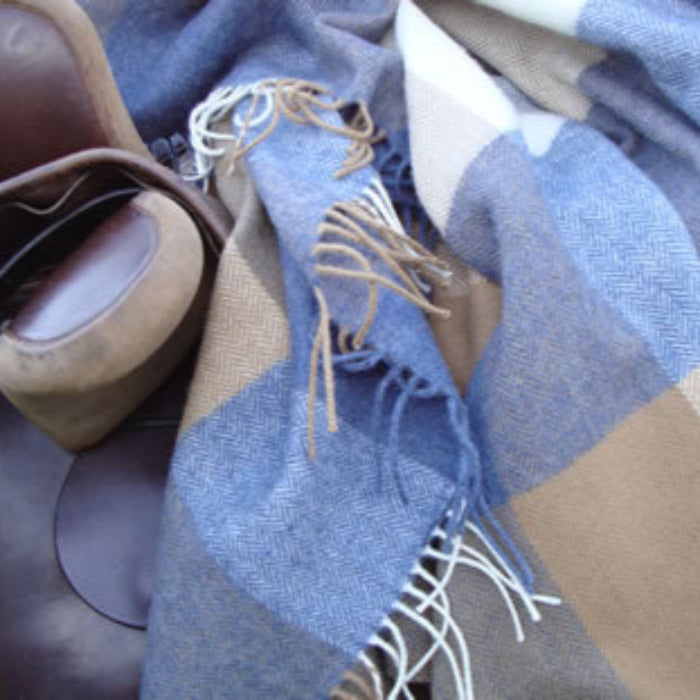Plaid lambswool throw with blue and tan pattern and fringes