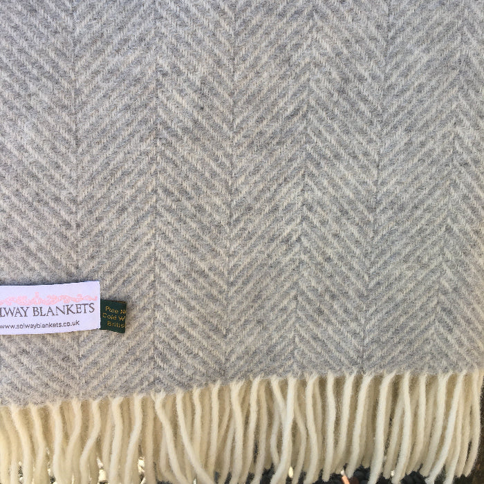 Silver grey and creamy white herringbone wool blanket with a visible Solway Blankets label.