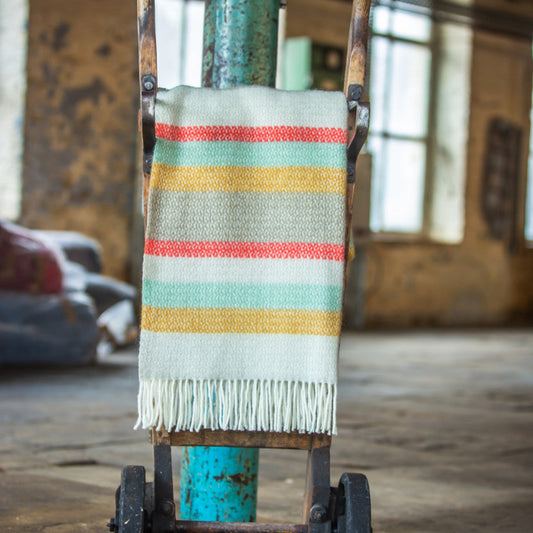 Colourful striped wool blanket on a vintage cart in an industrial setting