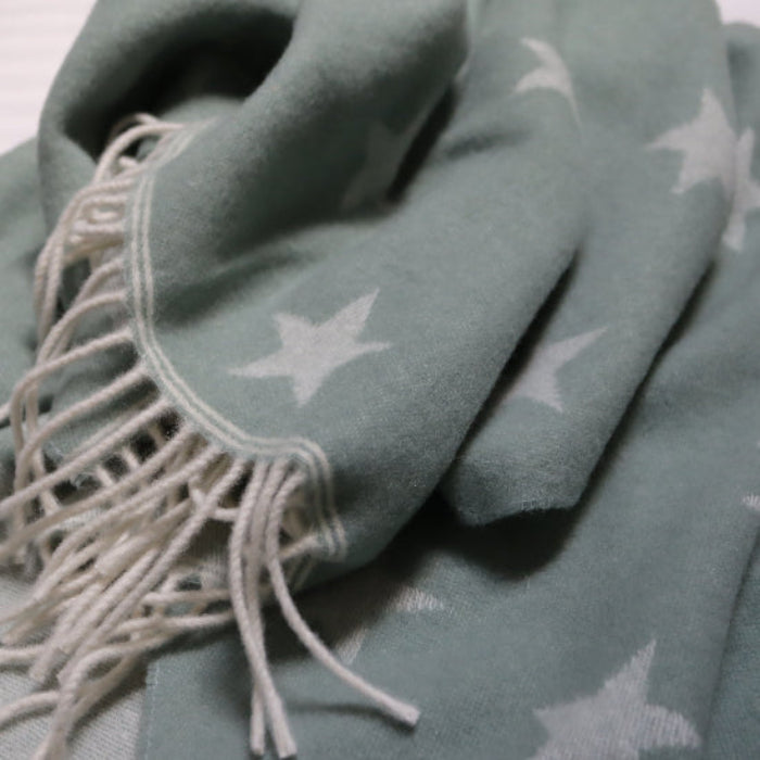 Star Sea Green Merino Wool Baby Blanket with tassels on a white background