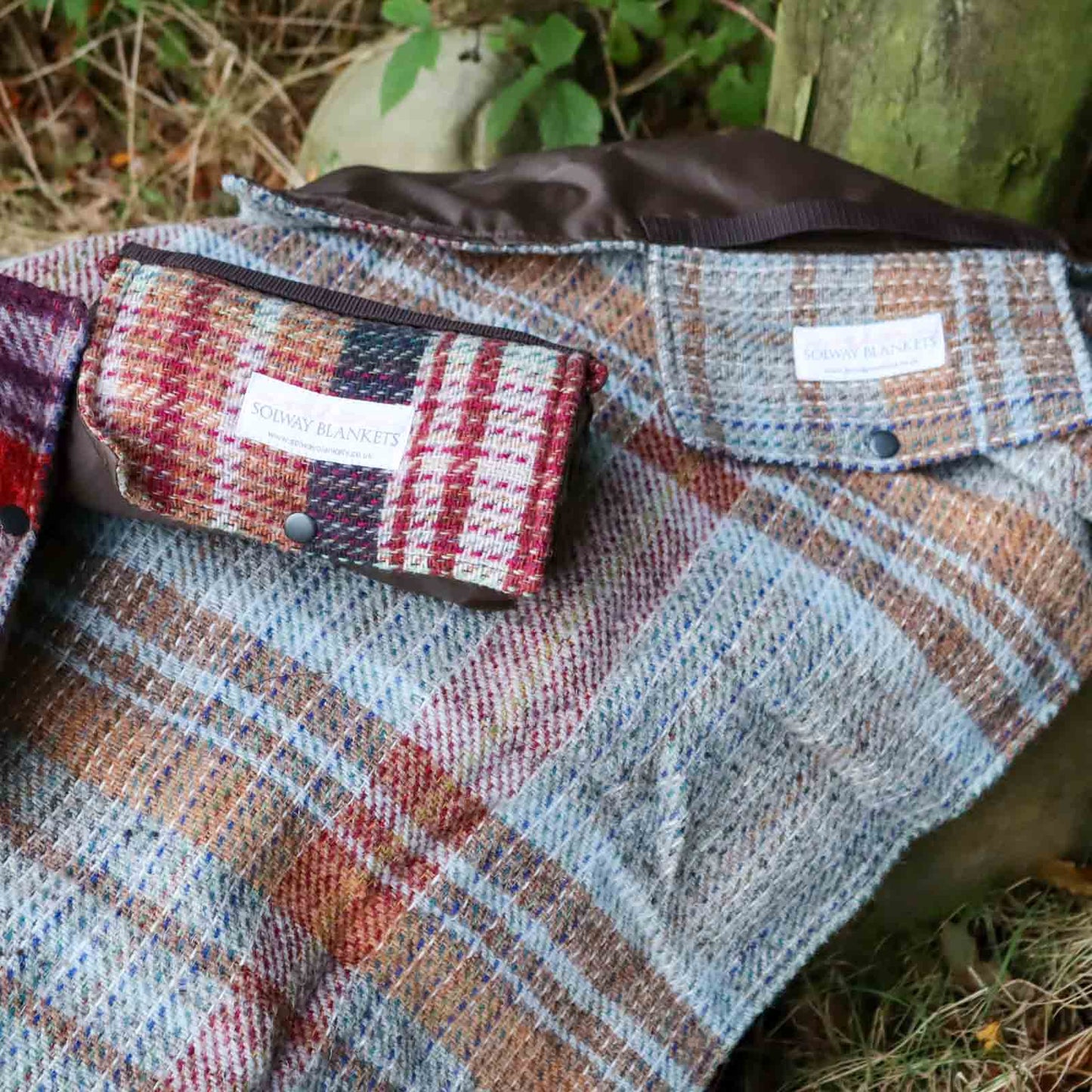 Random Recycled Waterproof Walker’s Companion Blanket laid out over a rock