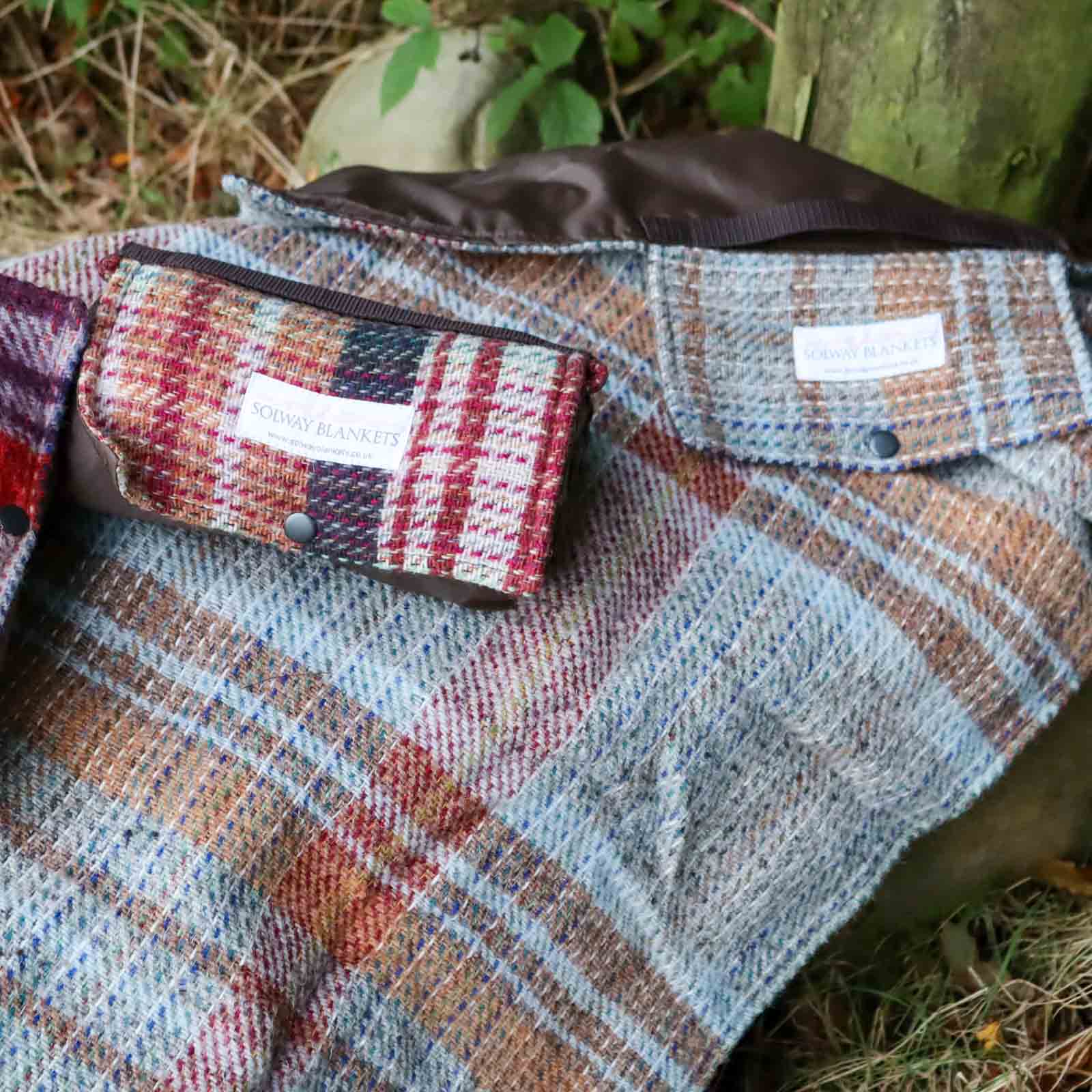 Random Recycled Waterproof Walker’s Companion Blanket laid out over a rock