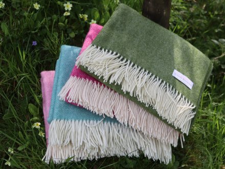 four shetland wool blankets in different colours stacked up